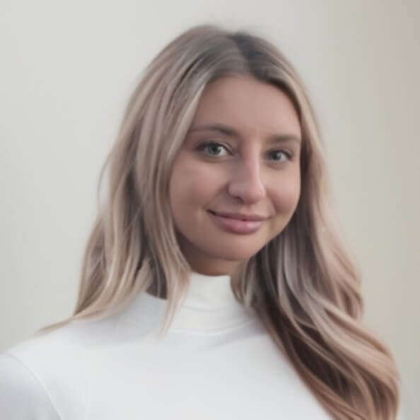 Sabrina Novak smiles in front of a gray background.